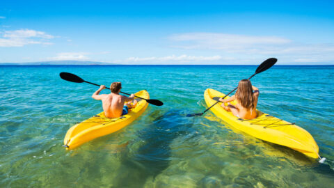 Two people paddling around Maui in kayaks